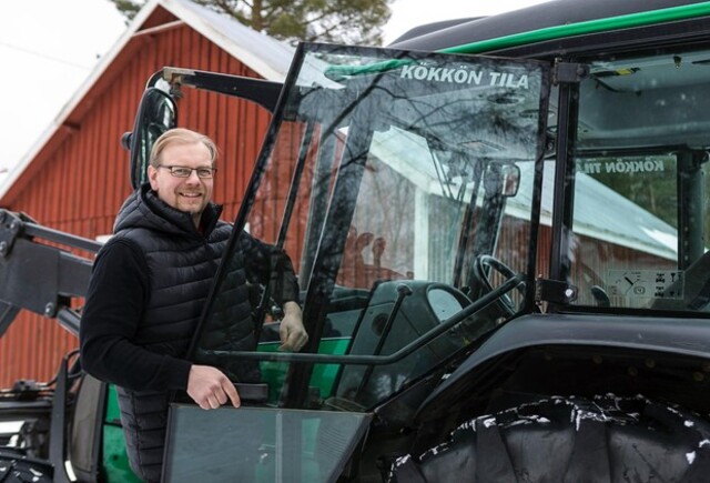 Uudempi Kökkötraktori II ja Kökkön tilan isäntä Jani Kurvinen traktorin rappusella nousemassa kyytiin.